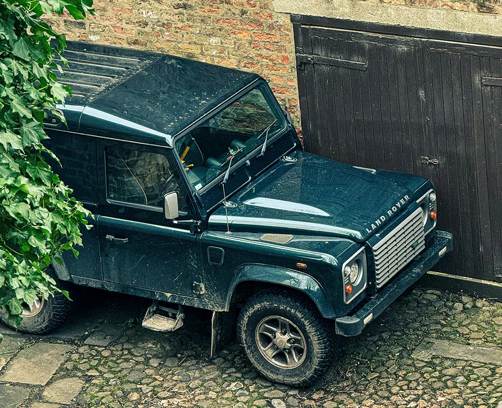 4×4 vehicle parked against a stone wall